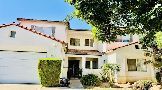 5346 W Flint Way, Fresno, CA 93722 - mediterranean / spanish-style house featuring a tile roof, stucco siding, and an attached garage