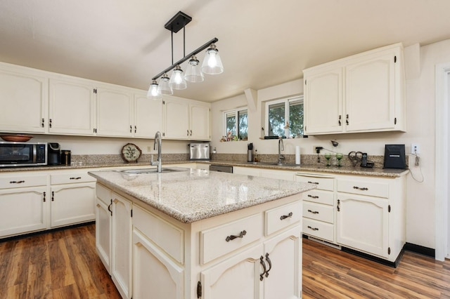 38303 Woodland Rd, Shaver Lake, CA 93664 - kitchen with appliances with stainless steel finishes, dark wood-type flooring, light stone countertops, an island with sink, and white cabinetry