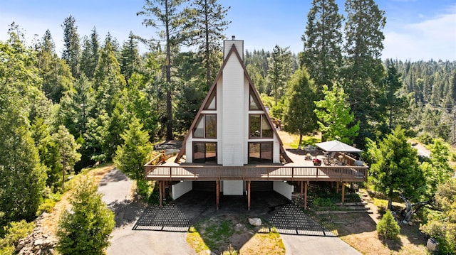 38303 Woodland Rd, Shaver Lake, CA 93664 - rear view of property featuring a view of trees, a wooden deck, and a chimney
