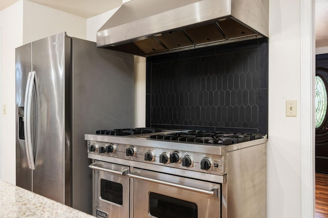 38303 Woodland Rd, Shaver Lake, CA 93664 - kitchen featuring range with two ovens, wall chimney range hood, decorative backsplash, wood finished floors, and light countertops