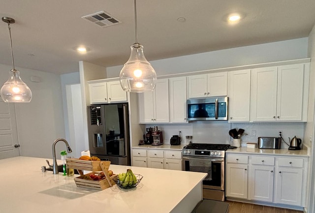 6423 E Robinson, Fresno, CA 93727 - kitchen featuring stainless steel appliances, white cabinets, light countertops, hanging light fixtures, and recessed lighting
