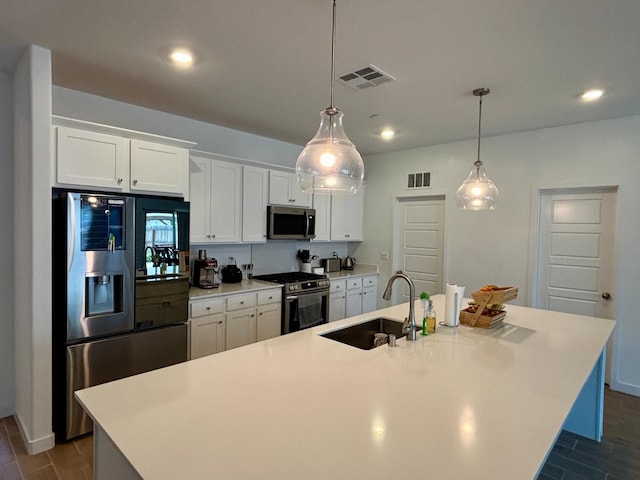 6423 E Robinson, Fresno, CA 93727 - kitchen featuring appliances with stainless steel finishes, a sink, a center island with sink, white cabinetry, and light countertops