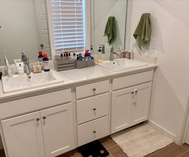 6423 E Robinson, Fresno, CA 93727 - bathroom featuring double vanity, wood finished floors, and a textured wall