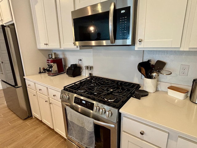 6423 E Robinson, Fresno, CA 93727 - kitchen featuring stainless steel appliances, light wood-style flooring, white cabinets, and light countertops
