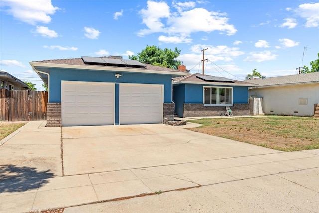 4003 E Fedora Ave, Fresno, CA 93726 - ranch-style home with brick siding, roof mounted solar panels, an attached garage, and driveway