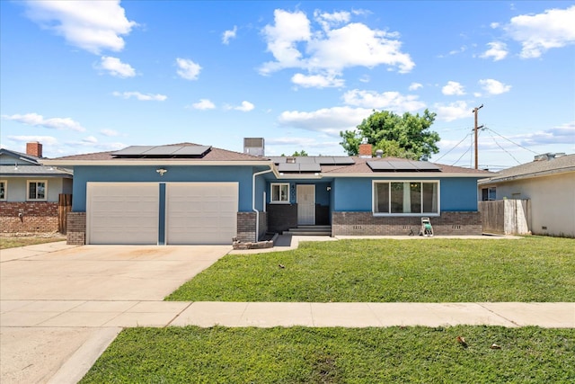 4003 E Fedora Ave, Fresno, CA 93726 - ranch-style home with brick siding, a garage, solar panels, driveway, and stucco siding