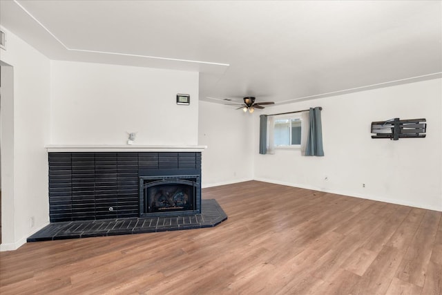4003 E Fedora Ave, Fresno, CA 93726 - unfurnished living room featuring wood finished floors, ceiling fan, a fireplace with raised hearth, and baseboards