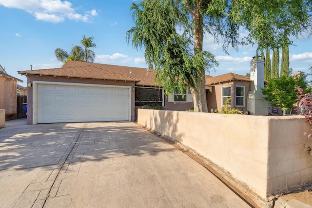 315 E Clinton Ave, Fresno, CA 93704 - view of front of property featuring stucco siding, driveway, and a chimney