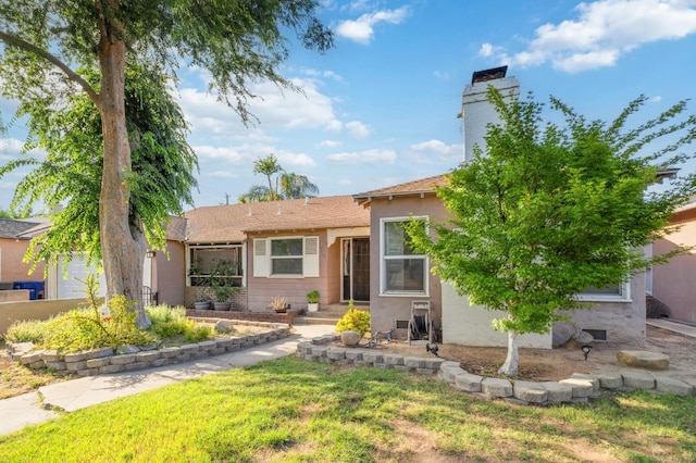 315 E Clinton Ave, Fresno, CA 93704 - view of front of property featuring a front lawn, stucco siding, and a chimney
