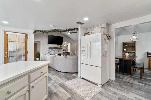 1958 Sundance Ln, Madera, CA 93637 - kitchen featuring white fridge with ice dispenser, a fireplace, light wood finished floors, white cabinetry, and recessed lighting