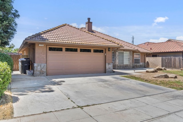 1958 Sundance Ln, Madera, CA 93637 - ranch-style home with stone siding, a tile roof, a garage, a chimney, and driveway