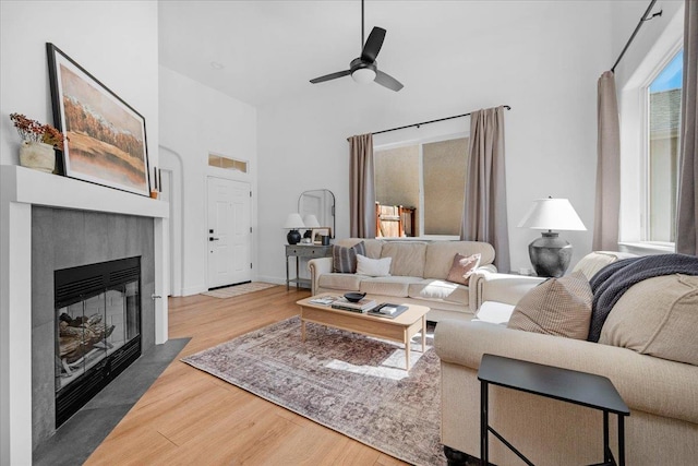 1780 N Avignon Ln, Clovis, CA 93619 - living room with wood finished floors, a high ceiling, a ceiling fan, a tiled fireplace, and baseboards