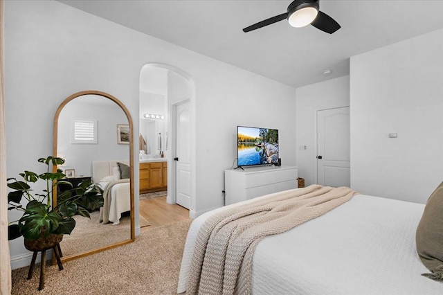 1780 N Avignon Ln, Clovis, CA 93619 - bedroom featuring arched walkways, light wood-type flooring, a ceiling fan, and ensuite bathroom