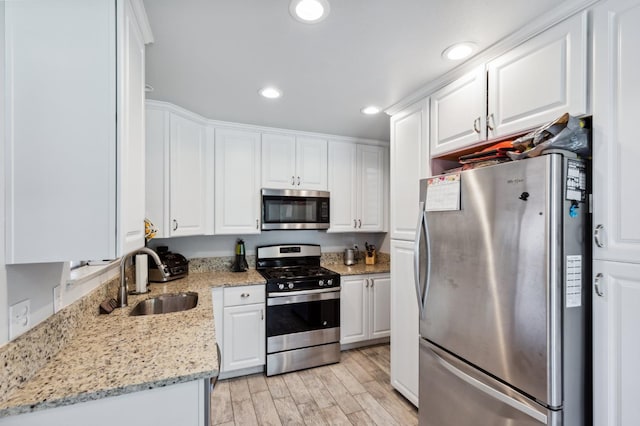 119 Magnolia Ave, Lemoore, CA 93245 - kitchen featuring appliances with stainless steel finishes, a sink, white cabinets, light wood finished floors, and recessed lighting