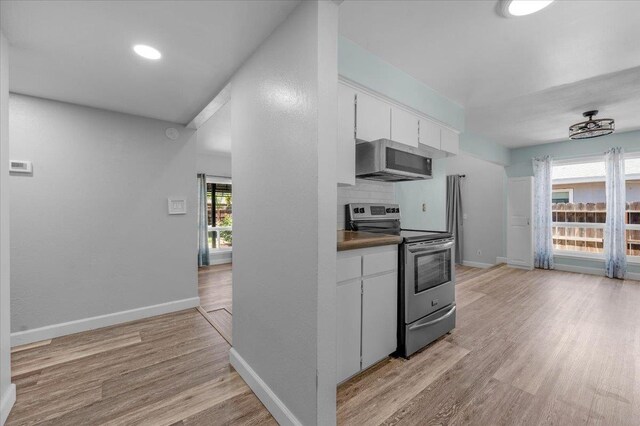 6569 N Kennedy Ave, Fresno, CA 93710 - kitchen with stainless steel appliances, white cabinets, light wood-type flooring, and baseboards