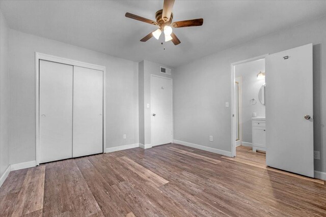 6569 N Kennedy Ave, Fresno, CA 93710 - unfurnished bedroom featuring wood finished floors, baseboards, a closet, ensuite bath, and ceiling fan