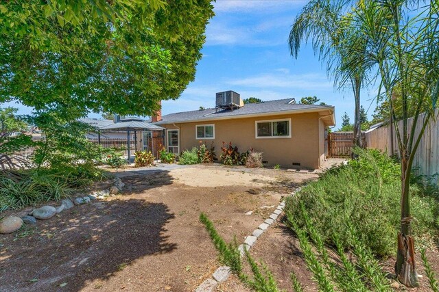 6569 N Kennedy Ave, Fresno, CA 93710 - back of property featuring a gazebo, crawl space, central air condition unit, and stucco siding