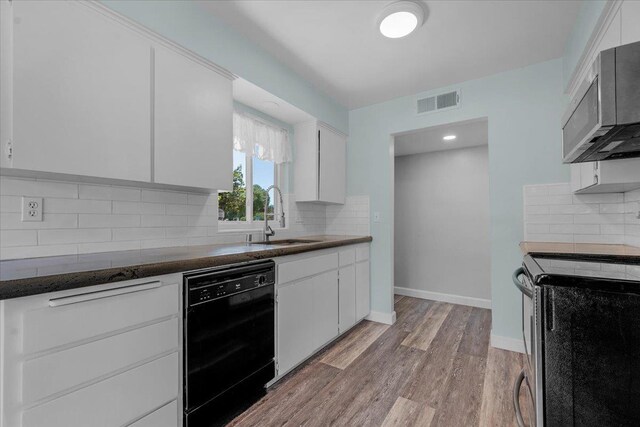 6569 N Kennedy Ave, Fresno, CA 93710 - kitchen featuring stainless steel appliances, a sink, light wood-type flooring, white cabinetry, and tasteful backsplash