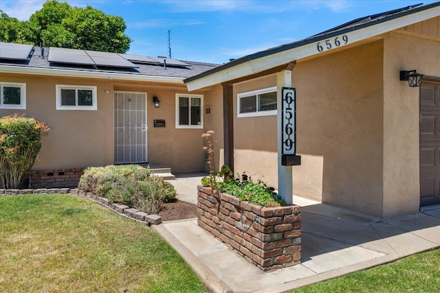 6569 N Kennedy Ave, Fresno, CA 93710 - view of exterior entry featuring solar panels and stucco siding
