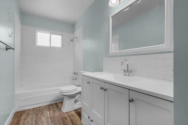 6569 N Kennedy Ave, Fresno, CA 93710 - bathroom featuring wood finished floors, vanity, toilet, bathtub / shower combination, and backsplash