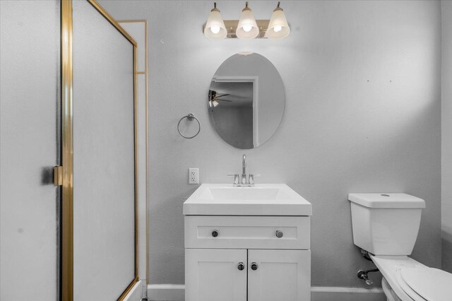 6569 N Kennedy Ave, Fresno, CA 93710 - bathroom with toilet, a stall shower, vanity, a ceiling fan, and baseboards
