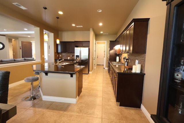 3309 Beverly Ave, Clovis, CA 93619 - kitchen with appliances with stainless steel finishes, dark countertops, backsplash, a kitchen bar, and recessed lighting