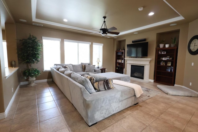 3309 Beverly Ave, Clovis, CA 93619 - living room featuring a raised ceiling, ceiling fan, a fireplace with raised hearth, light tile patterned floors, and recessed lighting