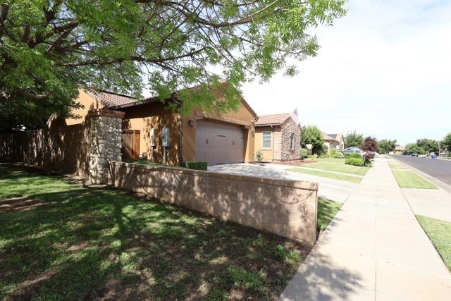3309 Beverly Ave, Clovis, CA 93619 - view of front of property featuring an attached garage, driveway, stone siding, stucco siding, and a front lawn
