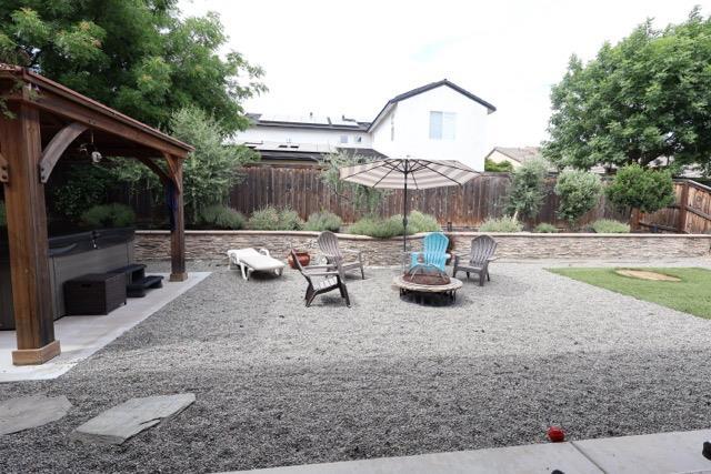 3309 Beverly Ave, Clovis, CA 93619 - fenced backyard with a fire pit, a patio area, and a gazebo