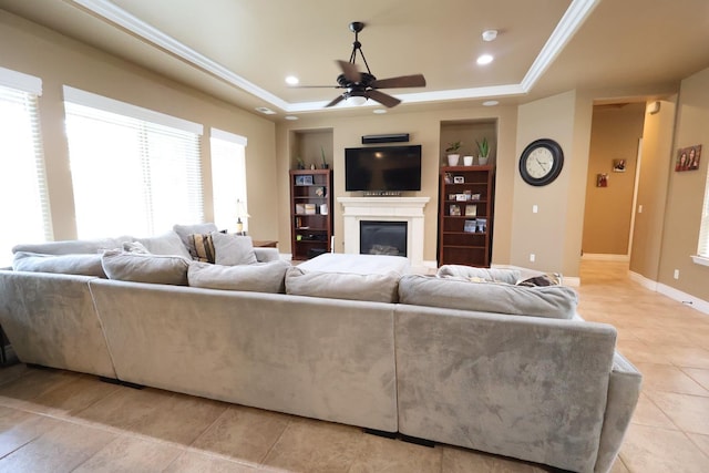 3309 Beverly Ave, Clovis, CA 93619 - living area with a raised ceiling, ceiling fan, light tile patterned flooring, a glass covered fireplace, and ornamental molding
