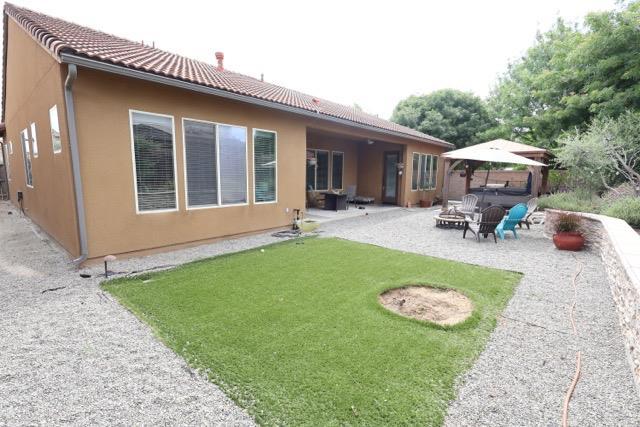 3309 Beverly Ave, Clovis, CA 93619 - back of property with a fire pit, a patio, a tiled roof, and stucco siding