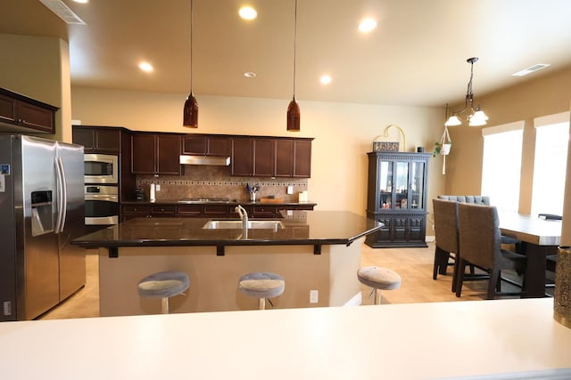 3309 Beverly Ave, Clovis, CA 93619 - kitchen featuring appliances with stainless steel finishes, a sink, a kitchen breakfast bar, dark brown cabinets, and recessed lighting