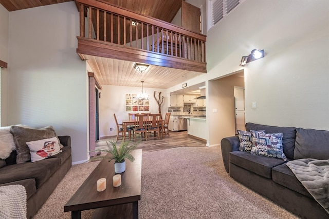40814 Village Pass Ln, Shaver Lake, CA 93664 - living area featuring light colored carpet, a chandelier, baseboards, wooden ceiling, and a high ceiling
