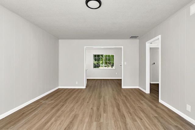708 E San Jose Ave, Fresno, CA 93710 - empty room featuring a textured ceiling, wood finished floors, baseboards, and crown molding