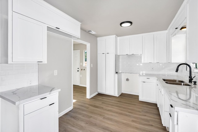 708 E San Jose Ave, Fresno, CA 93710 - kitchen featuring a sink, light stone countertops, tasteful backsplash, and light wood-type flooring