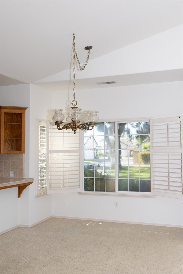 2300 Sierra Ave Unit 129, Kingsburg, CA 93631 - unfurnished dining area featuring a chandelier, vaulted ceiling, and baseboards