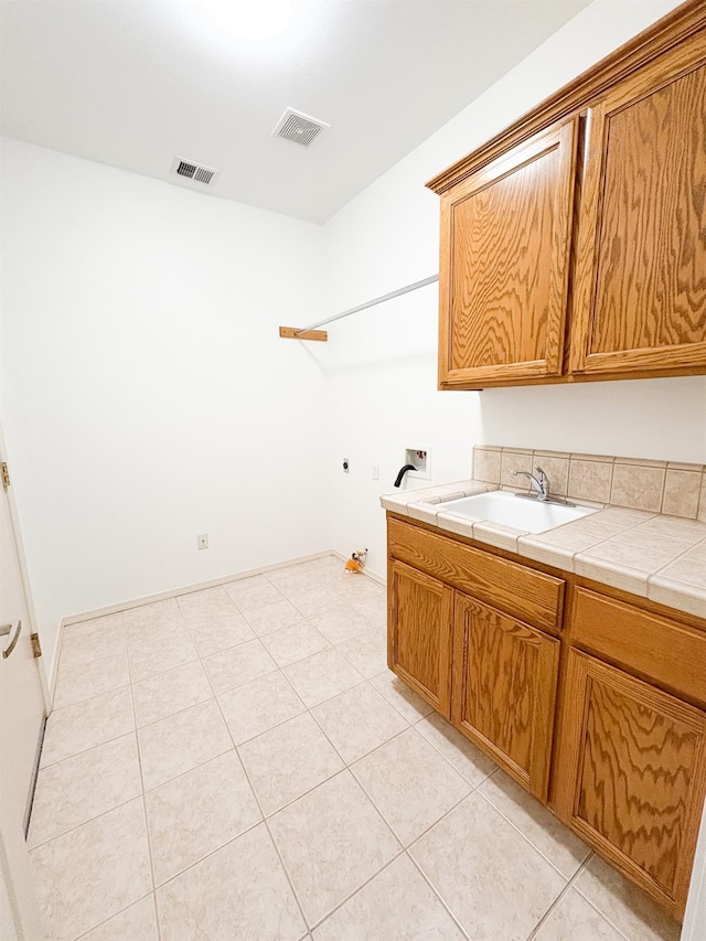2300 Sierra Ave Unit 129, Kingsburg, CA 93631 - washroom featuring cabinet space, washer hookup, and light tile patterned floors