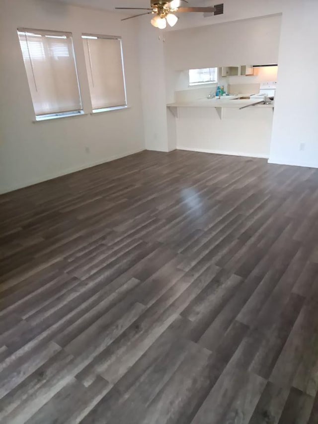 3332 W Shields Ave Unit 101, Fresno, CA 93722 - unfurnished living room featuring dark wood finished floors and a ceiling fan