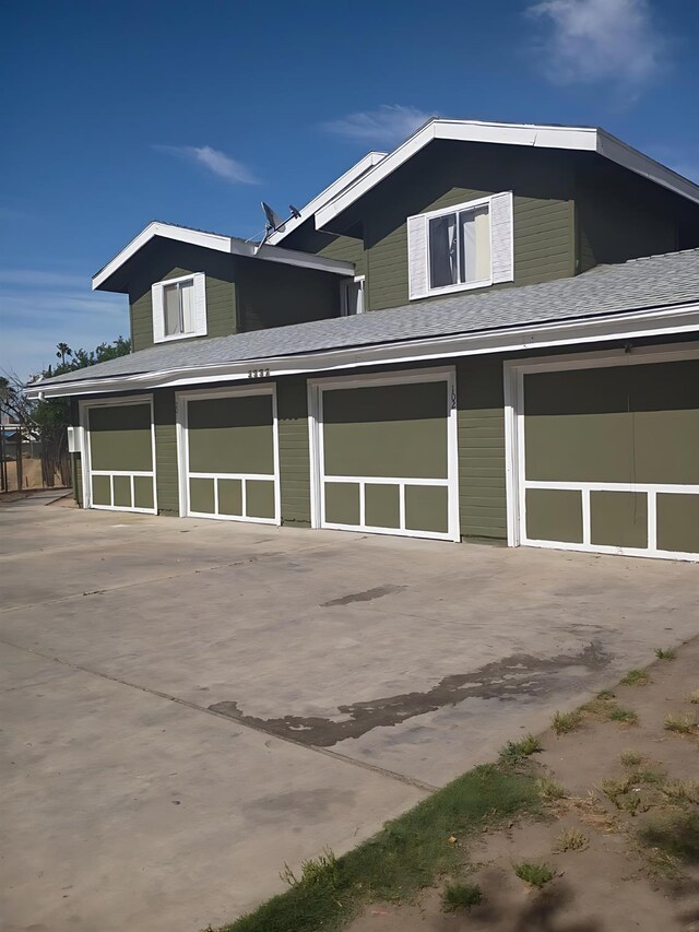 3332 W Shields Ave Unit 101, Fresno, CA 93722 - view of home's exterior with an attached garage, concrete driveway, and roof with shingles