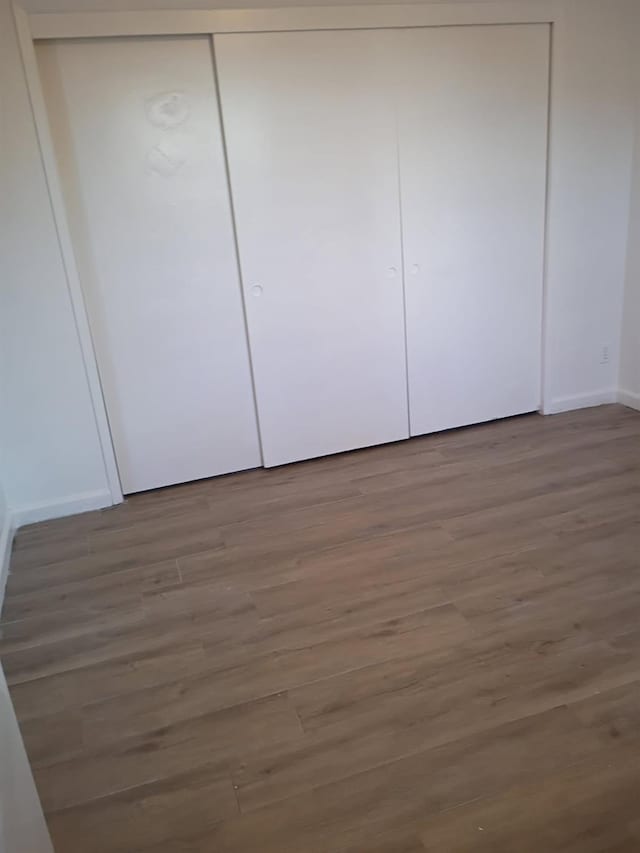 3332 W Shields Ave Unit 101, Fresno, CA 93722 - unfurnished bedroom with wood finished floors, baseboards, and a closet