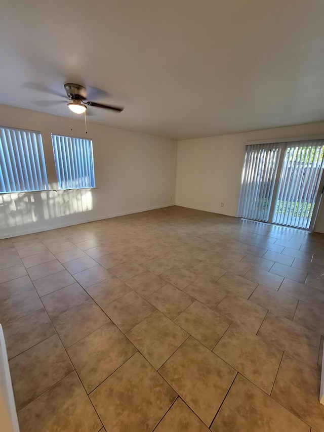 3332 W Shields Ave Unit 101, Fresno, CA 93722 - empty room with light tile patterned floors, ceiling fan, and baseboards