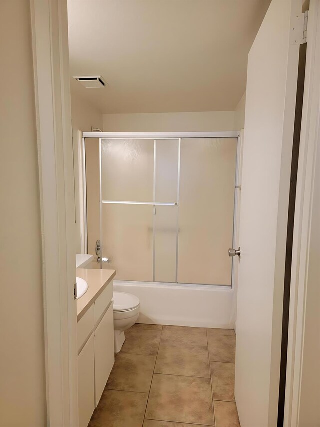 3332 W Shields Ave Unit 101, Fresno, CA 93722 - bathroom featuring vanity, toilet, tile patterned flooring, and bath / shower combo with glass door