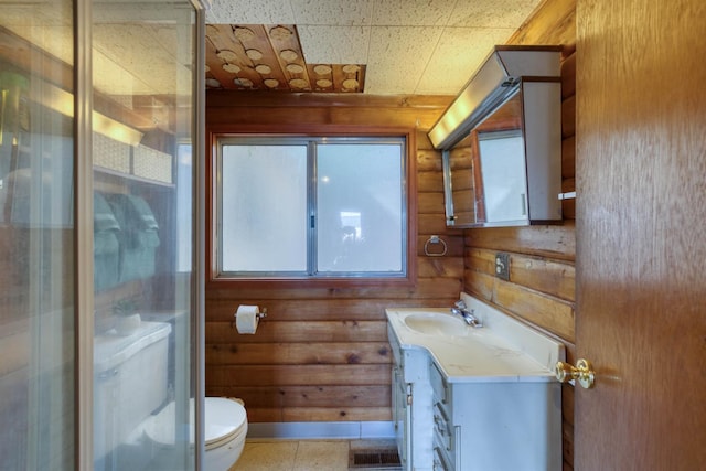 44468 Lakeview Ave, Shaver Lake, CA 93664 - bathroom with vanity, toilet, a stall shower, and wood walls