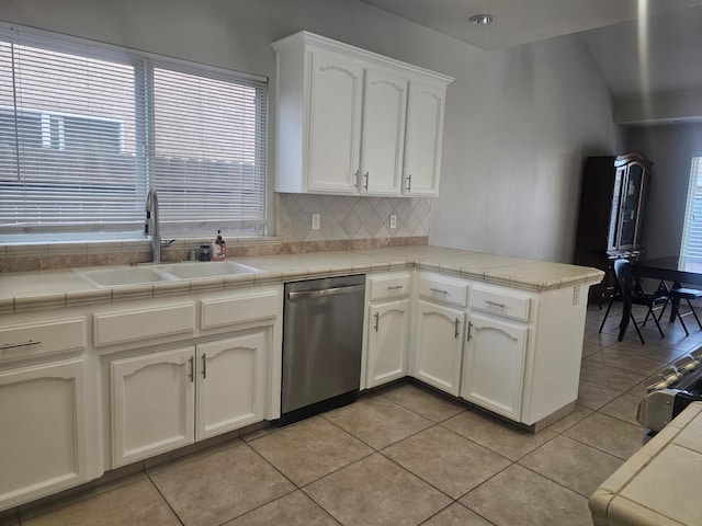 3351 Winter Way, Madera, CA 93637 - kitchen with stainless steel dishwasher, a sink, a peninsula, decorative backsplash, and white cabinets