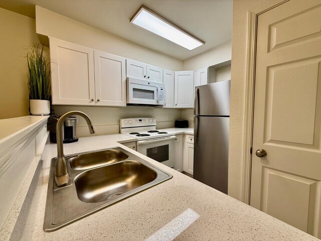 2909 Huntington Blvd Unit 207, Fresno, CA 93721 - kitchen featuring white appliances, a sink, and white cabinetry