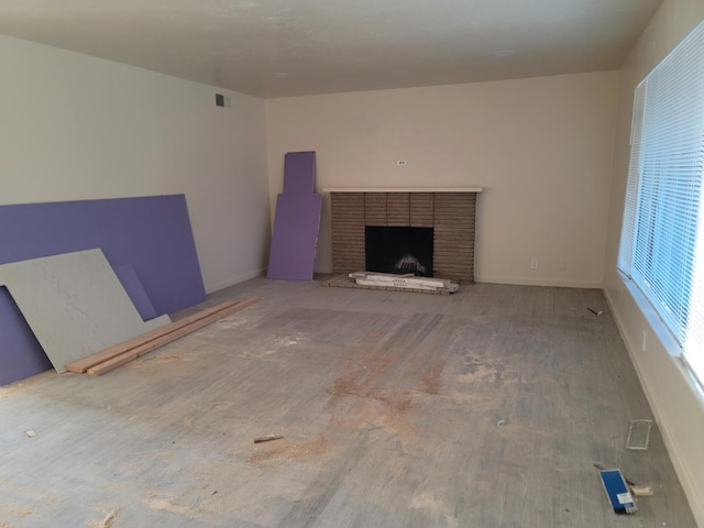 3023 E Robinson Ave, Fresno, CA 93726 - unfurnished living room with a brick fireplace, wood finished floors, and baseboards