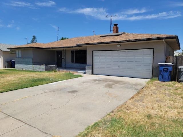 3023 E Robinson Ave, Fresno, CA 93726 - ranch-style home with driveway, solar panels, an attached garage, and brick siding