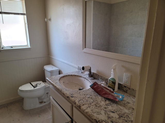3023 E Robinson Ave, Fresno, CA 93726 - bathroom featuring vanity, toilet, a wainscoted wall, and tile patterned flooring