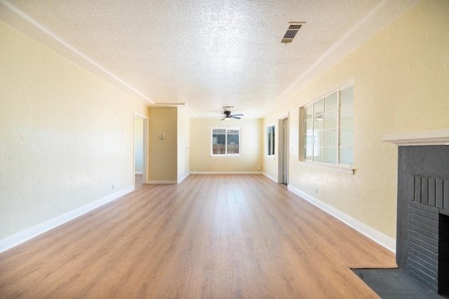 2744 E Michigan Ave, Fresno, CA 93703 - unfurnished living room featuring a brick fireplace, a textured ceiling, light wood finished floors, a ceiling fan, and baseboards