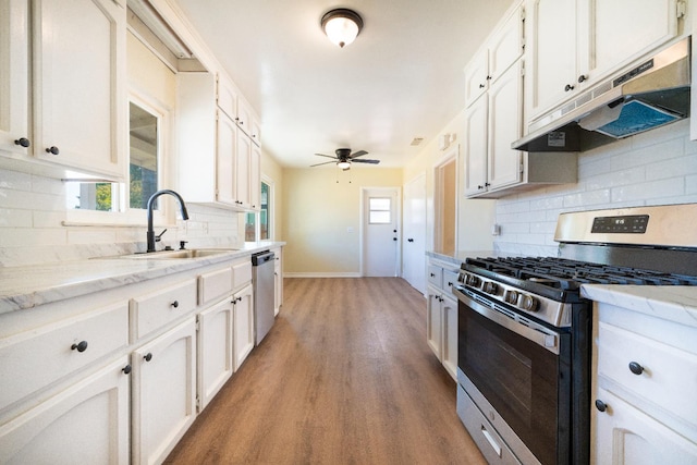 2744 E Michigan Ave, Fresno, CA 93703 - kitchen featuring stainless steel appliances, under cabinet range hood, a sink, baseboards, and white cabinetry